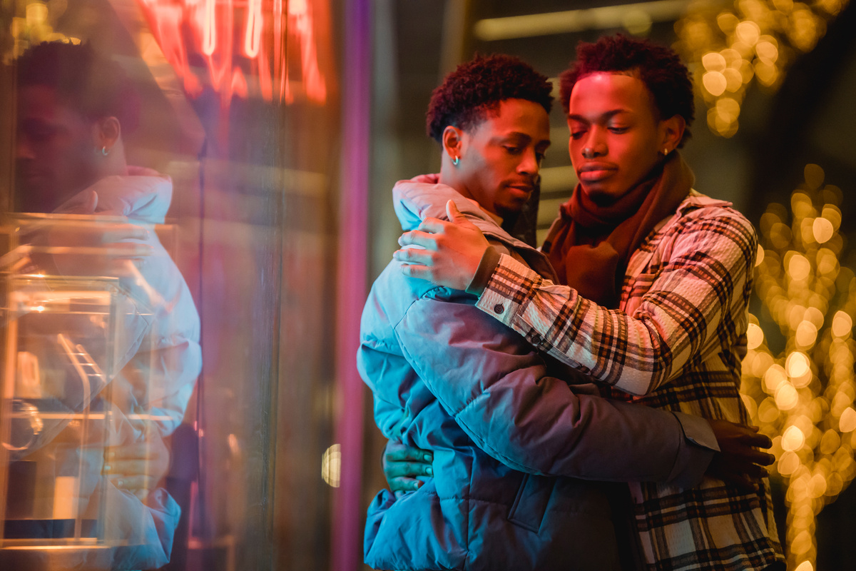 Loving homosexual black men embracing on street at night